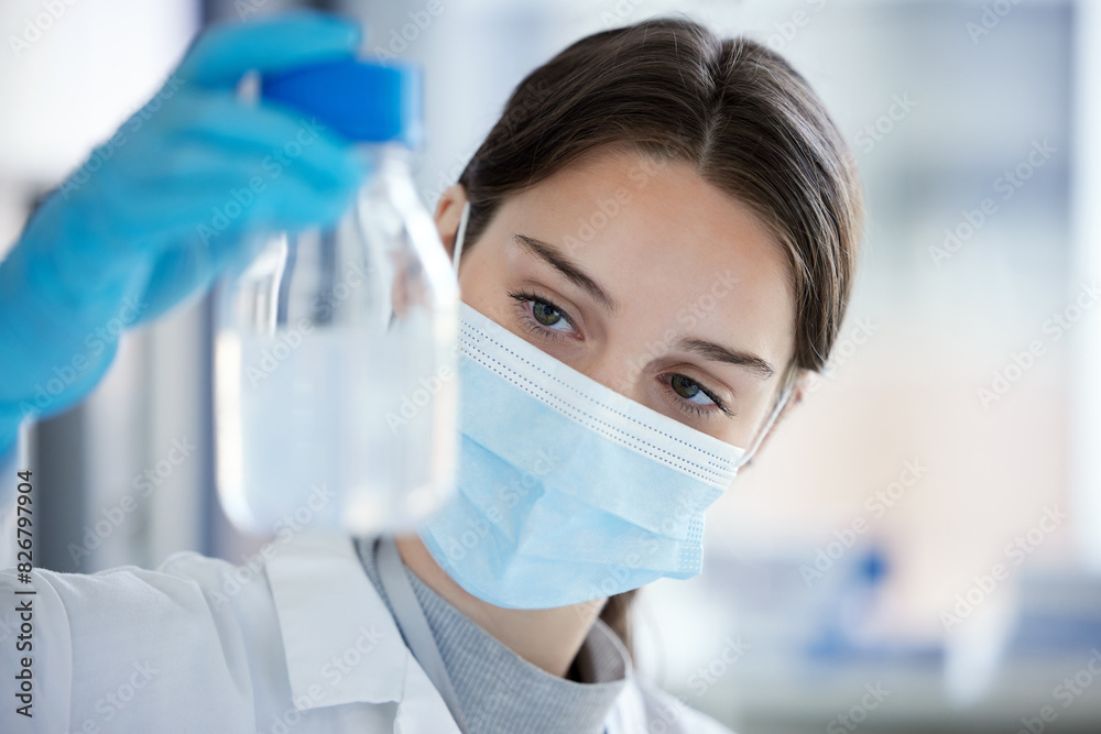 Science, bottle and woman with mask, liquid in container or medical research in laboratory. Vaccine innovation, scientist or lab technician with solution, glass or pharmaceutical development with ppe Science, bottle and woman with mask, liquid in container or medical research in laboratory. Vaccine innovation, scientist or lab technician with solution, glass or pharmaceutical development with ppe