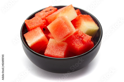 A black ceramic bowl filled with Organic watermelon (citrullus Lanatus) pieces. Isolated on a white background.