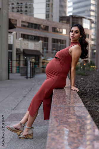 Portrait of a pregnant woman in a red dress in a maternity shoot in Downtown Phoenix, Arizona.