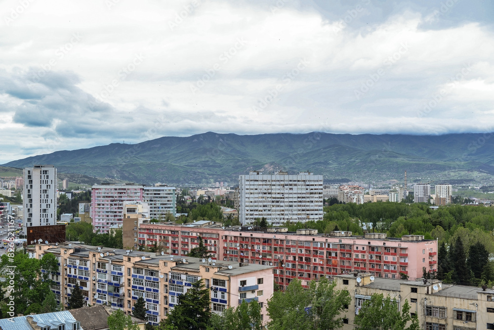 Naklejka premium clouds over the residential area of Tbilisi with mountains on a background