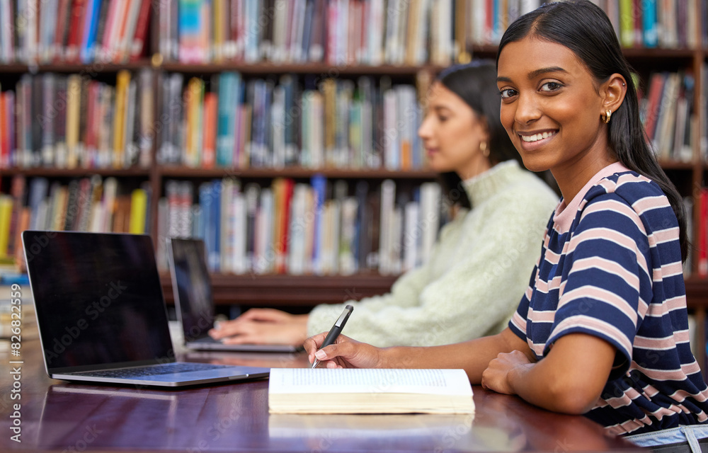 Portrait, university and woman in library with laptop, research and writing notes with bookshelf. Smile, book and student with notebook for scholarship, study and opportunity for college education Portrait, university and woman in library with laptop, research and writing notes with bookshelf. Smile, book and student with notebook for scholarship, study and opportunity for college education