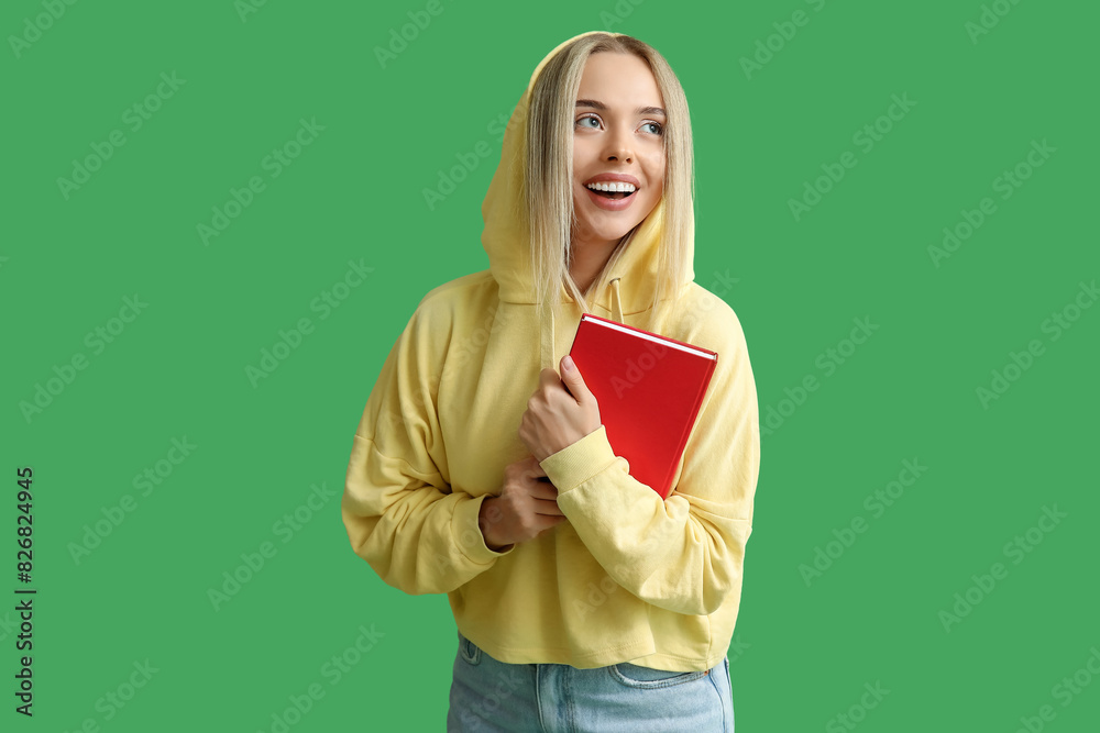Beautiful young happy woman with book on green background Beautiful young happy woman with book on green background