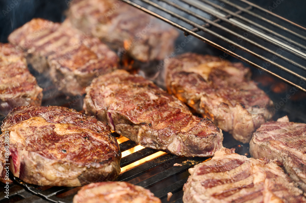 Black Angus steaks are grilled on a barbecue grill. Smoked steaks on the grill