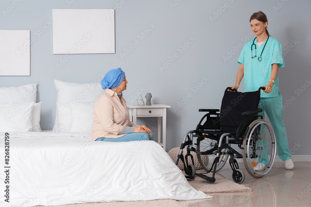 Mature woman after chemotherapy and nurse with wheelchair in bedroom. Stomach cancer concept Mature woman after chemotherapy and nurse with wheelchair in bedroom. Stomach cancer concept