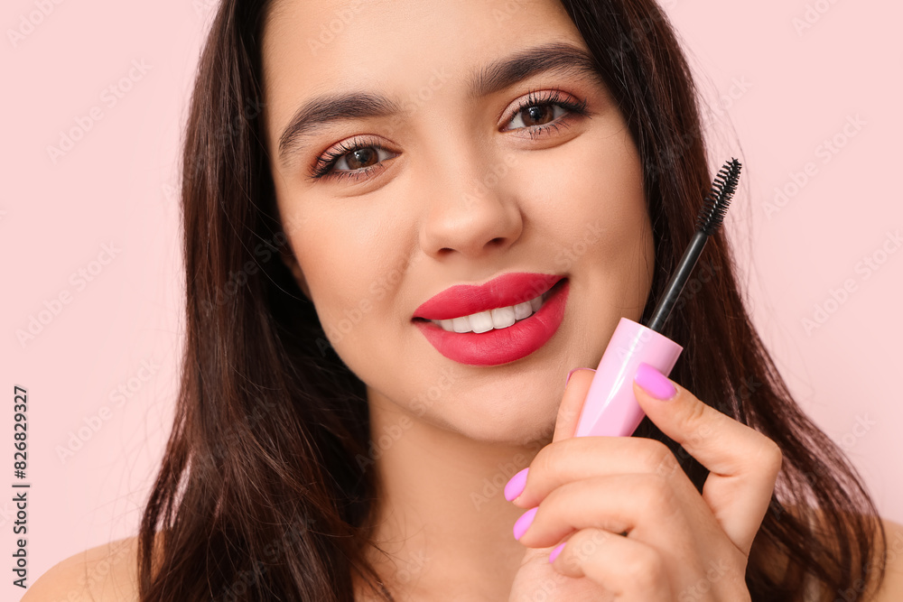 Beautiful young happy woman with mascara on pink background Beautiful young happy woman with mascara on pink background