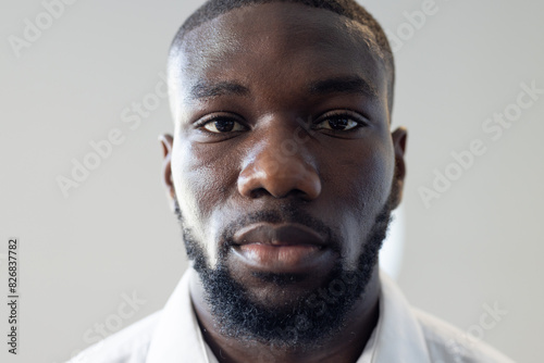 At modern office, young African American man with short hair and beard looks forward photo