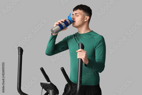 Sporty young man drinking w...