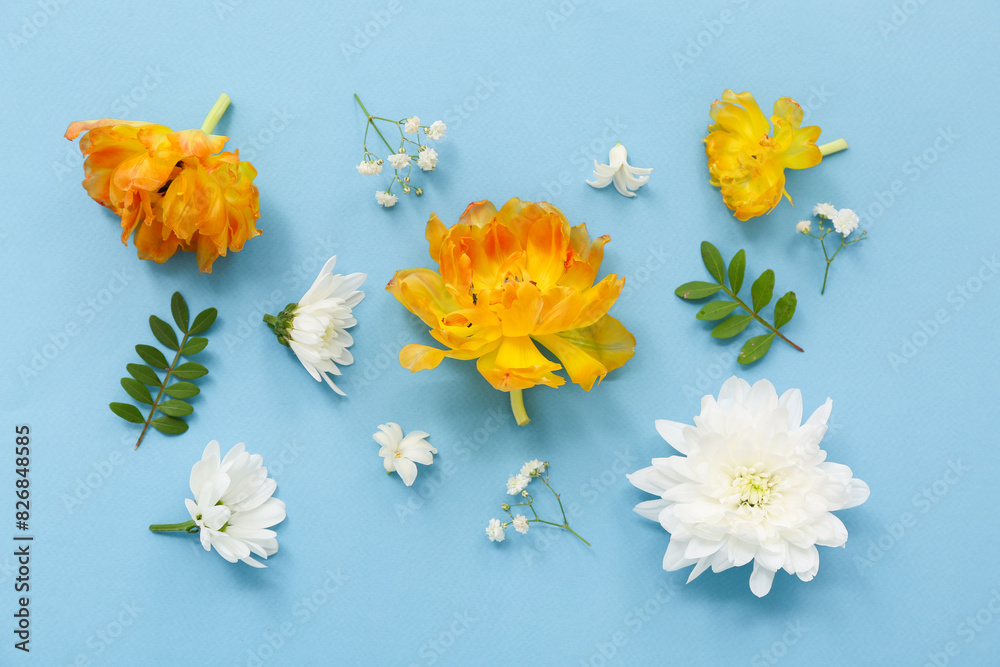 Obraz premium Beautiful composition with different flowers and green leaves on blue background