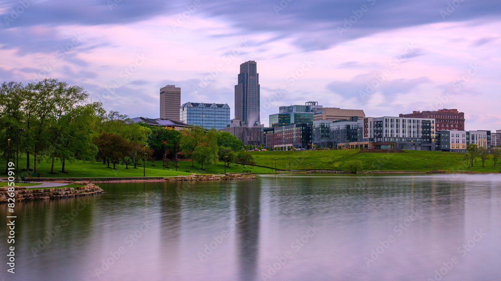 Omaha City Skyline, high-rising buildings, peaceful lake, big sky with floating clouds: The beauty of the midwestern metropolis in Nebraska