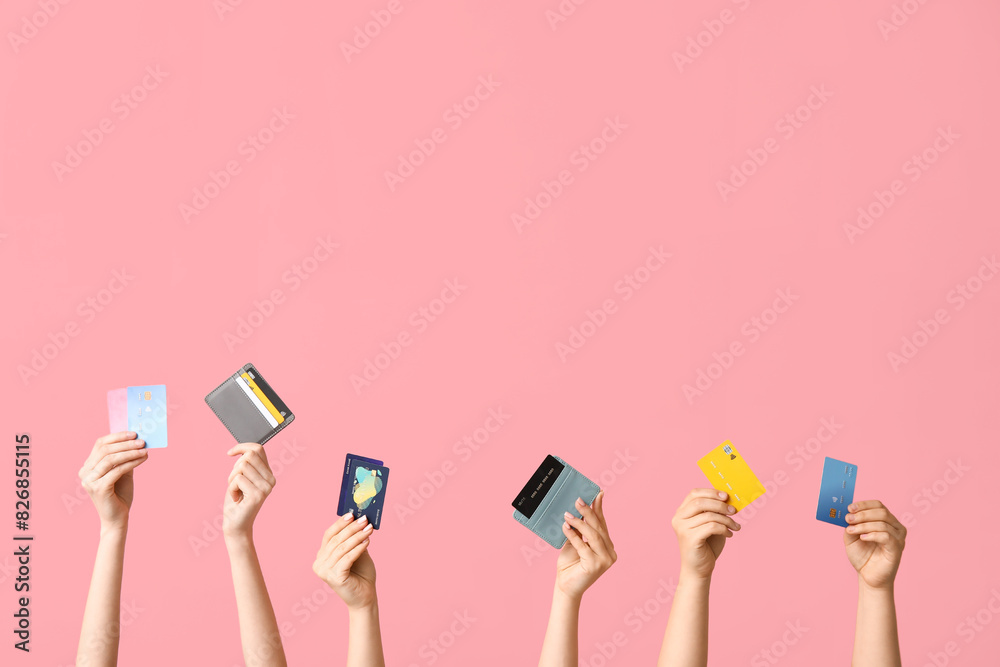 Female hands with credit cards on pink background Female hands with credit cards on pink background
