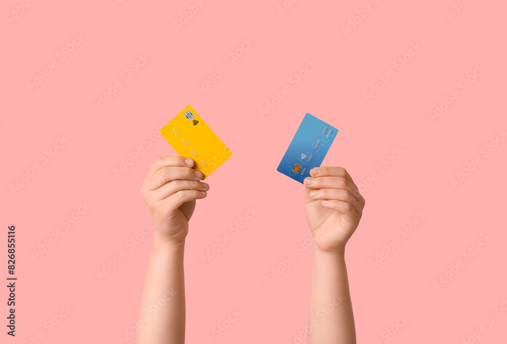 Female hands with credit cards on pink background Female hands with credit cards on pink background