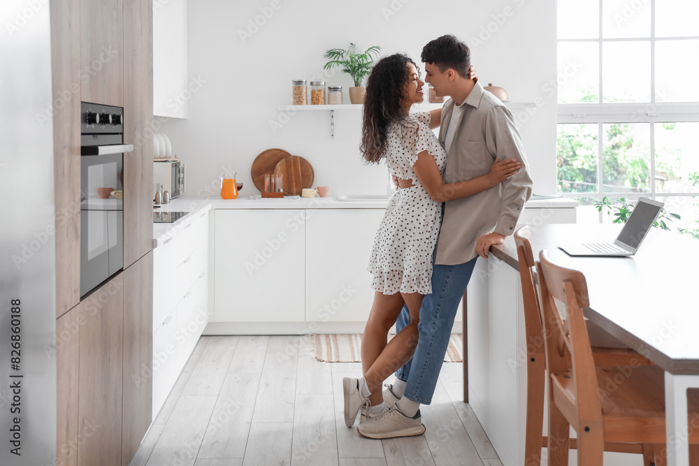 Young loving couple hugging in kitchen