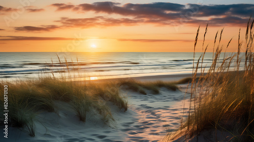 Golden sunset over a sandy beach with tall grass swaying in the breeze, waves gently lapping at the shore, creating a serene and picturesque coastal scene