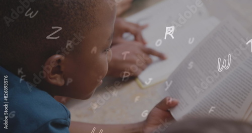 Image of letters over african american schoolboy reading