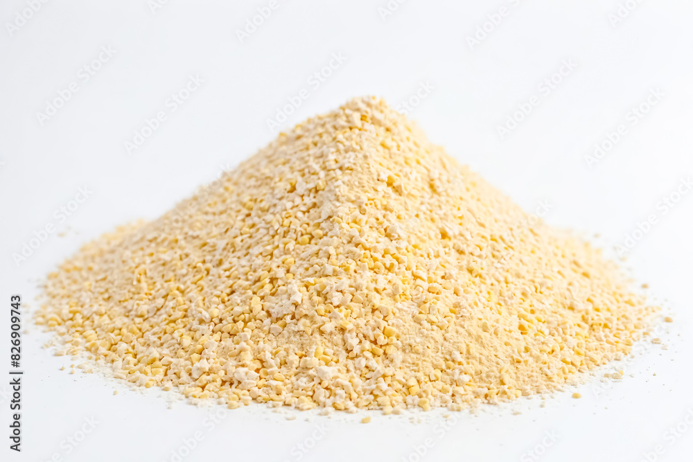 Close-up of a pile of yellow corn grits on a white background