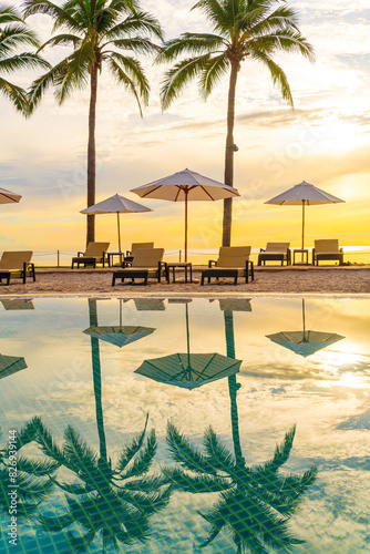Umbrella and chair around swimming pool in resort hotel for leisure travel and vacation neary sea ocean beach