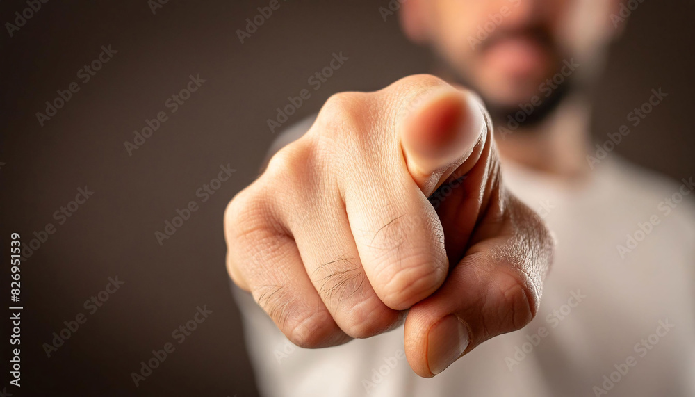 Close-up of a right hand pointing directly at the viewer, sharp focus on the fingertip, blurred person, dark background, direction, urgency, tension, command. Close-up of a right hand pointing directly at the viewer, sharp focus on the fingertip, blurred person, dark background, direction, urgency, tension, command.