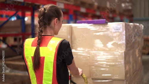 Female warehouse staff pushing a handlift or pallet lifter cart.