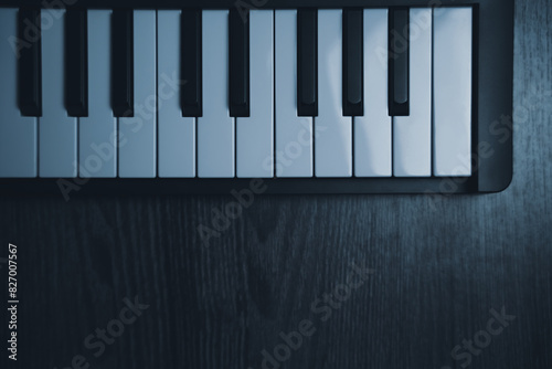 Black midi keyboard on a wooden table. Musical instrument