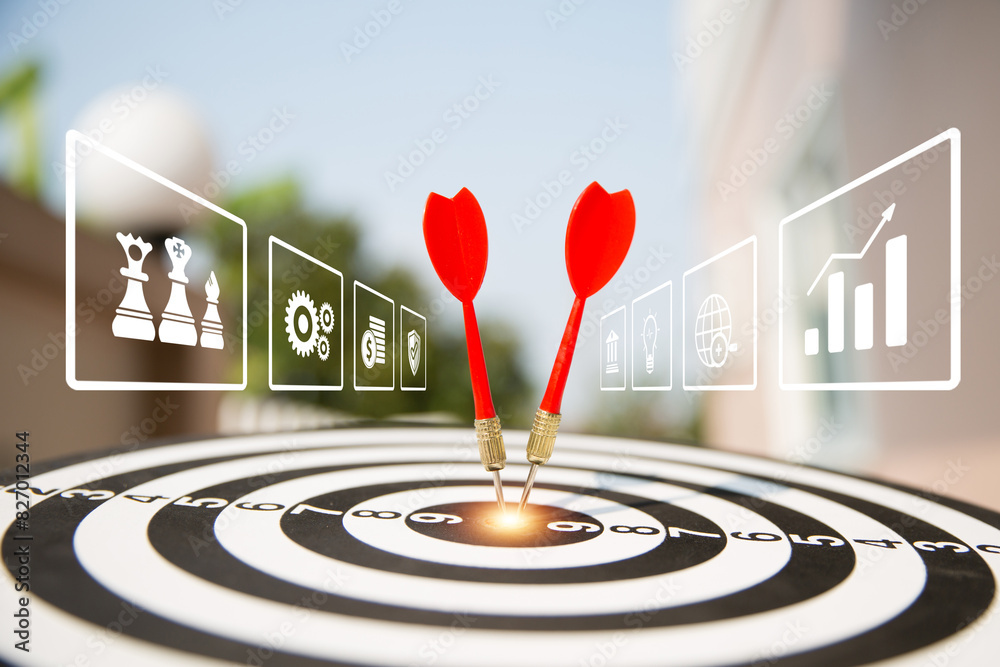 Target bullseye or Bulls eye and hand and red dart arrow throw hitting the center of a shooting with financial business targeting planning growth icons for aim to winner goal of business win concept. Target bullseye or Bulls eye and hand and red dart arrow throw hitting the center of a shooting with financial business targeting planning growth icons for aim to winner goal of business win concept.