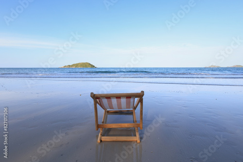 Wooden lounge chairs on a beautiful tropical beach photo