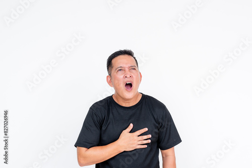 Fotografie A middle aged asian man having trouble breathing, gasping for air