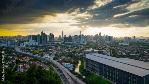 An establish aerial hyperlapse shot of Kuala Lumpur city overseeing the main four towers skyscrappers over a Middle Ring road highway photo