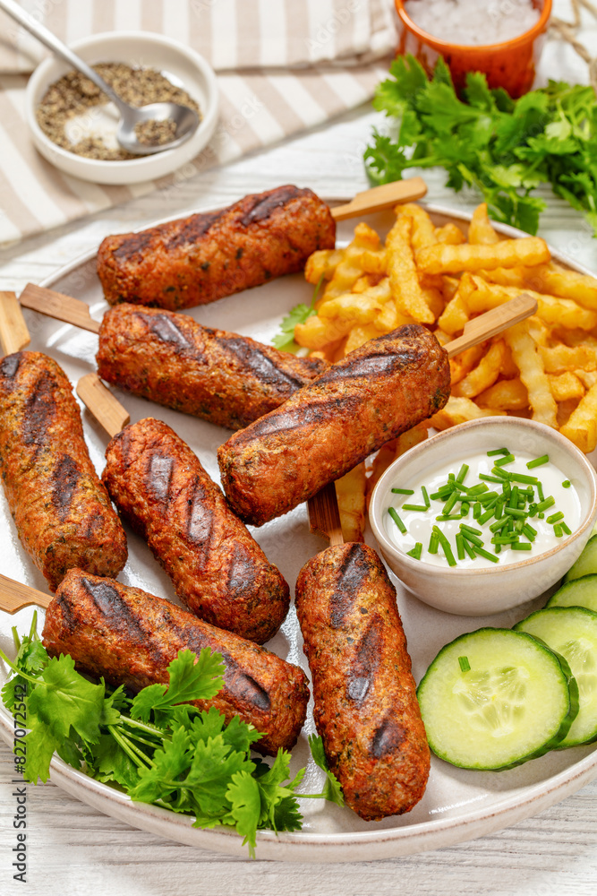 minced beef skewers with potato fries on plate minced beef skewers with potato fries on plate