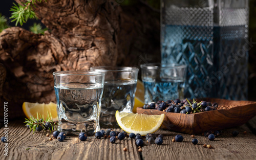 Gin with ingredients on an old wooden table.