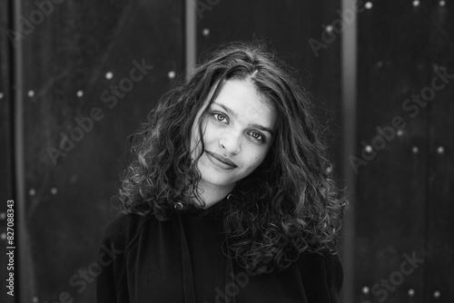 photo with a portrait of a schoolgirl or teenager with curly hair and beautiful eyes in black and white.