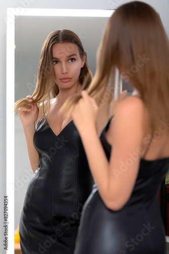 Beautiful slim woman posing against mirror