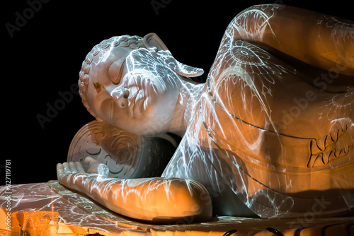 Nirvana white marble reclining Buddha, beautiful, black background.