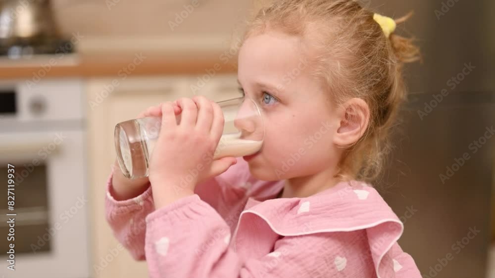 Close-up side shot of a girl drinking milk from a glass Close-up side shot of a girl drinking milk from a glass