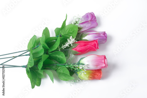 Colorful bouquet of artificial roses with green leaves on white background