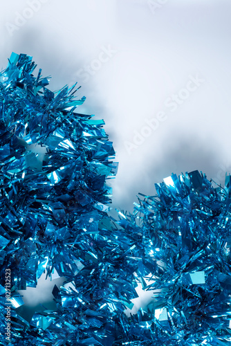 Blue tinsel on a white background with copy space for text. Concept of Christmas and New Year.