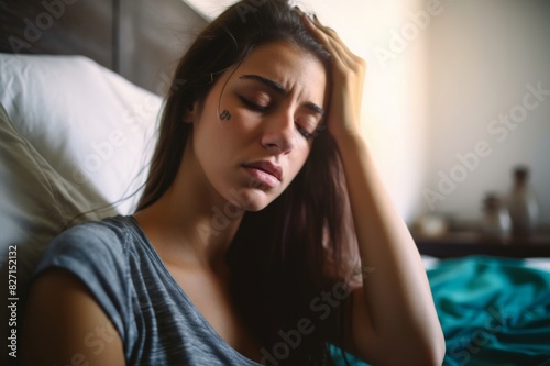 close-up of a young woman on bed having a headache in morning