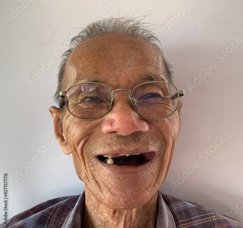The old man wore glasses and smiled with one tooth.