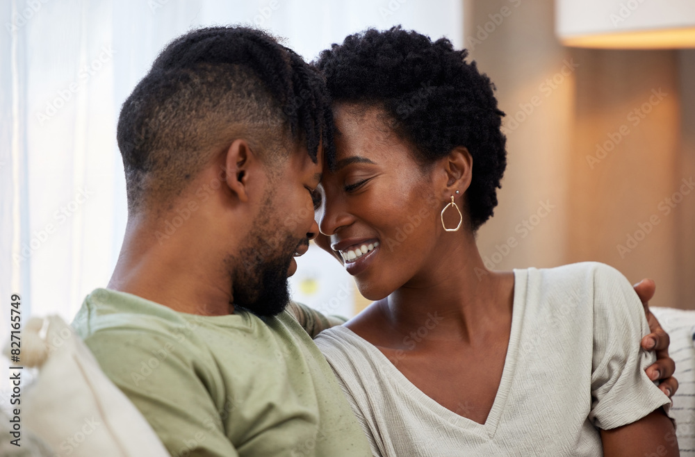 African couple, love and smile in home for commitment, marriage and together on sofa for relax. Man, woman and happy in apartment for morning, partner and romance in living room for bonding on couch