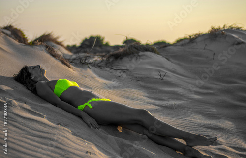 the woman in the yellow bikini collects the last rays of the setting sun