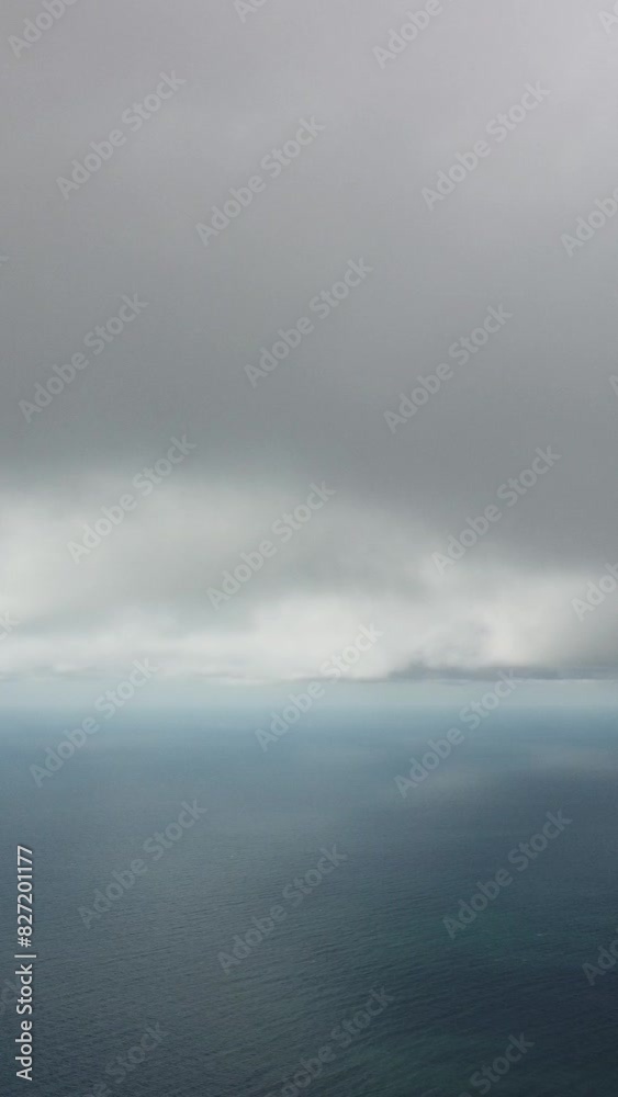 Aerial vertical view. Dramatic moody and gloomy rain clouds over sea. Abstract aerial nature summer ocean sunset sea and sky. Horizon. Vacation, travel and holiday concept. Weather and climate change Aerial vertical view. Dramatic moody and gloomy rain clouds over sea. Abstract aerial nature summer ocean sunset sea and sky. Horizon. Vacation, travel and holiday concept. Weather and climate change