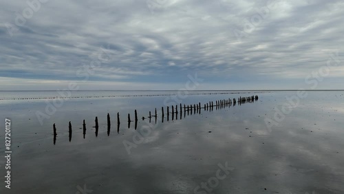 Aerial View: Wadden Sea near Wierum, Friesland, Netherlands with Wooden Posts and Stunning Cloud Reflections photo