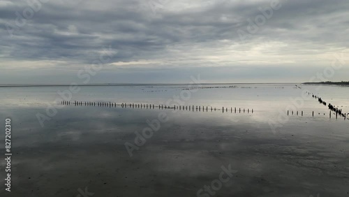 Aerial View: Wadden Sea near Wierum, Friesland, Netherlands with Wooden Posts and Stunning Cloud Reflections photo