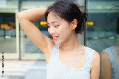 close up of pretty young asian woman smile looking away holding hair