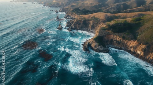 Stunning aerial shot capturing the dynamic coastline with cliffs and waves at golden hour