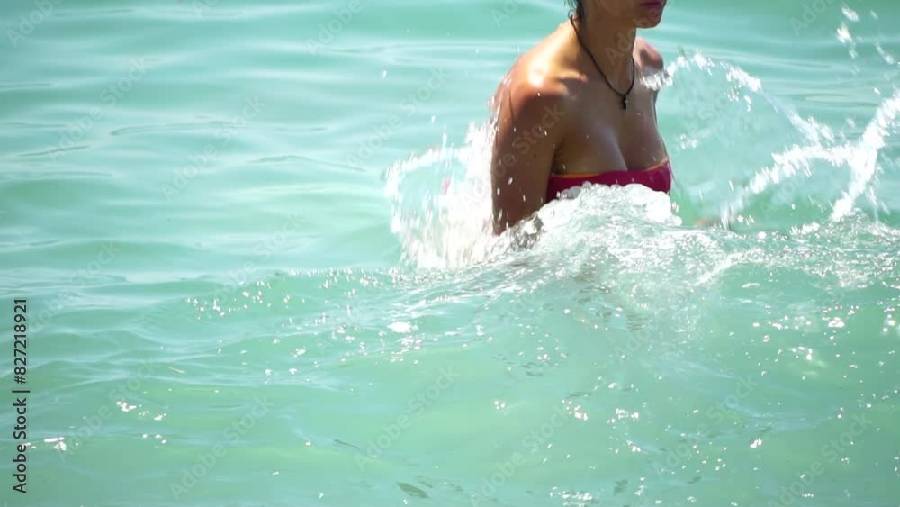 Woman swimming in calm sea at sunset, slow-motion, back view. Concept of body image and fitness, enjoying a serene beach. Happy woman with perfect fit body enjoys sea beach Woman swimming in calm sea at sunset, slow-motion, back view. Concept of body image and fitness, enjoying a serene beach. Happy woman with perfect fit body enjoys sea beach