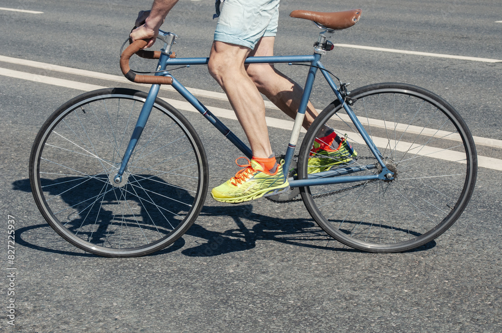 Hipster man rides on his fixed gear bicycle on asphalt roadway Hipster man rides on his fixed gear bicycle on asphalt roadway