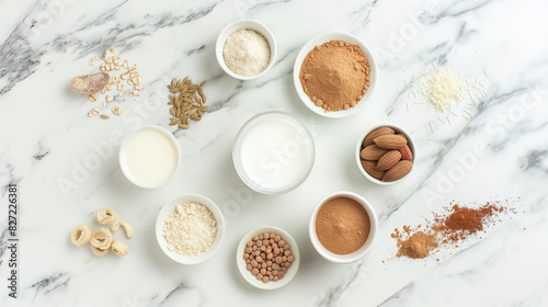 flat lay of various types of plant-based milk and milks, including shea cream, almond novelty vanilla, and brown sugar powder on a white marble surface