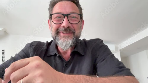 One man alone at home using phone camera to enjoy a videocall with friend online. Talking and having fun on video call people. Dating mature male. Using smartphone to call parents, during travel