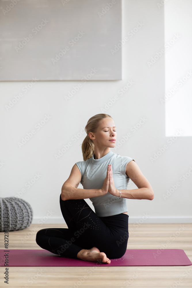 Fototapeta premium Woman meditating, practicing yoga, doing relaxation exercises at home. Meditation, yoga, balance, mindfulness, workout, relaxation, healthy lifestyle concept