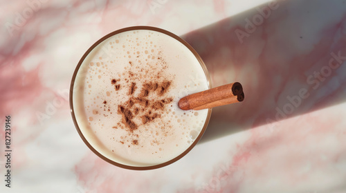 Cinematic photo of Mexican horchata in a glass with a cinnamon stick, aerial view, on a white and pink marble background
